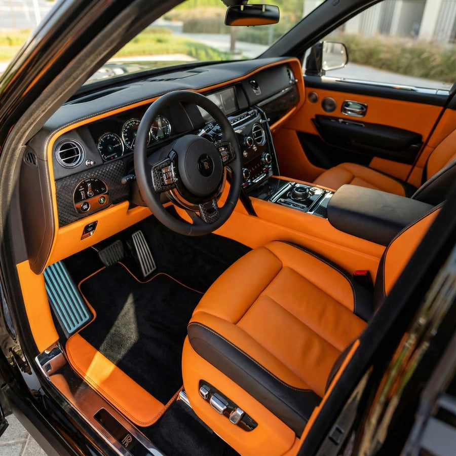 Personalizowane czarne maty samochodowe do Rolls Royce Cullinan z pomarańczową skórą